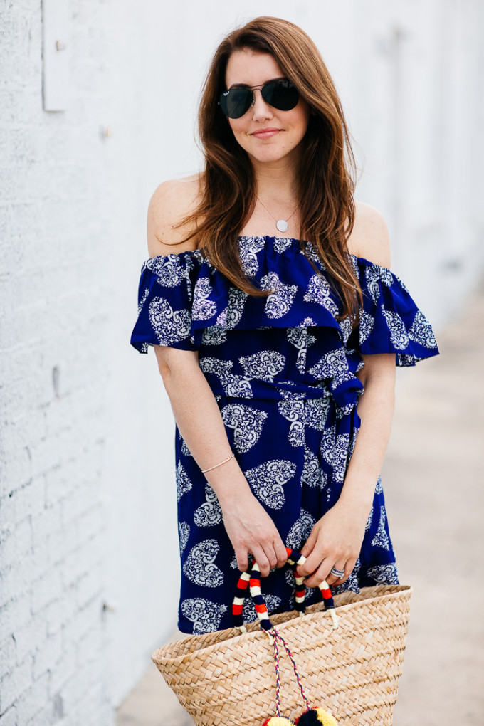 Amy Havins wears a blue off the shoulder dress with flat sandals.