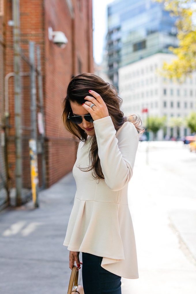 Amy Havins wears a pink peplum blouse with dark skinny jeans.