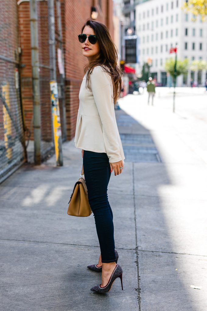 Amy Havins wears a pink peplum blouse with dark skinny jeans.