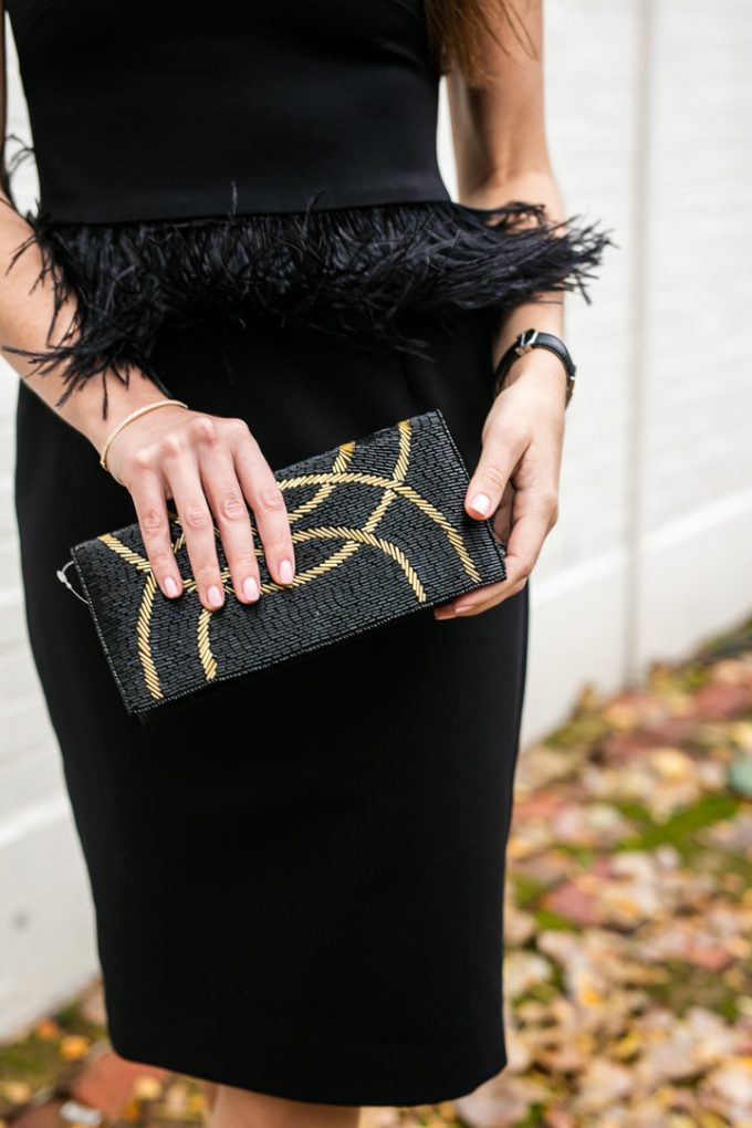 Amy Havins wears a black dress with feather accents from Camillyn Beth.