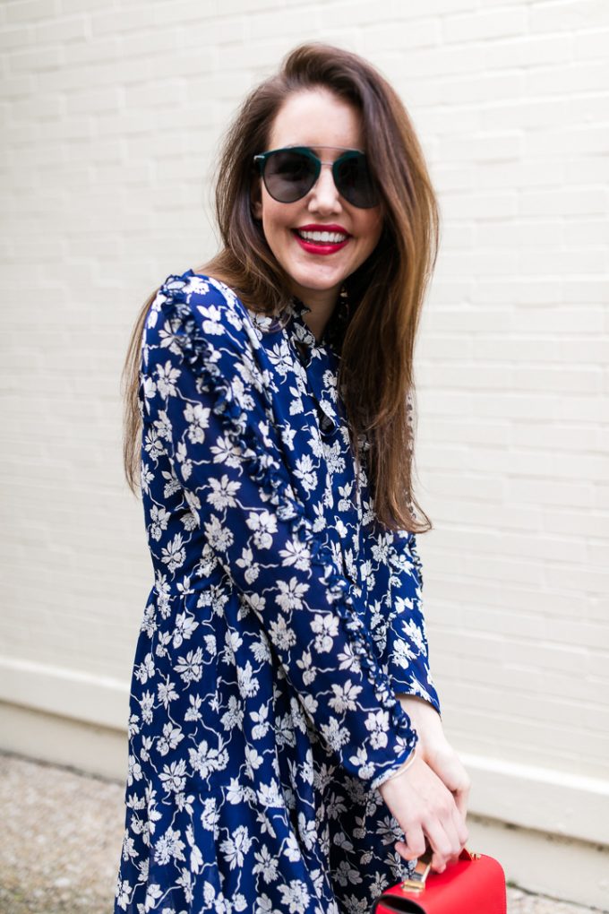 Amy havins wears a navy and white floral print shoshanna long sleeve dress with over the knee boots.