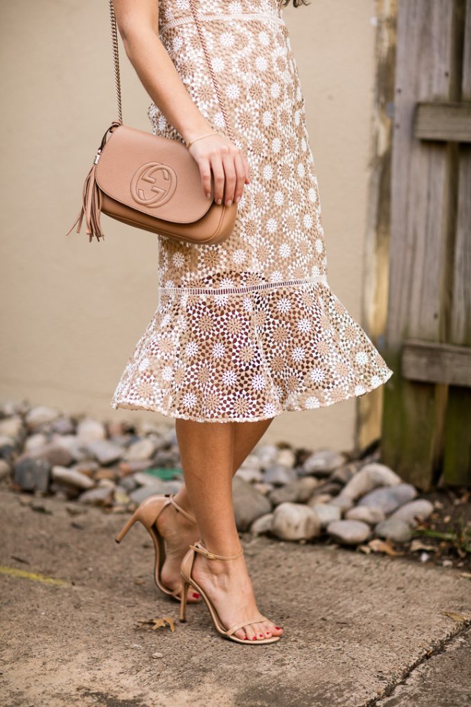 Amy Havins wears a Shoshanna cream and white lace midi dress.