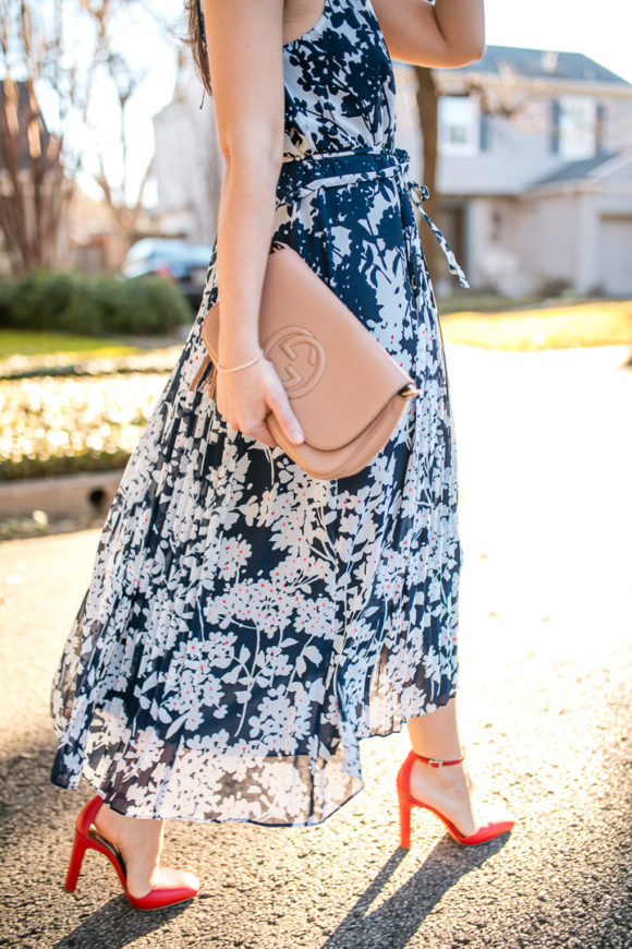 Amy Havins wears a printed midi dress and red heels. 