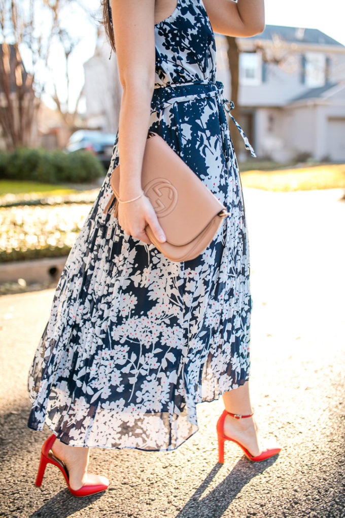 Amy Havins wears a printed midi dress and red heels.