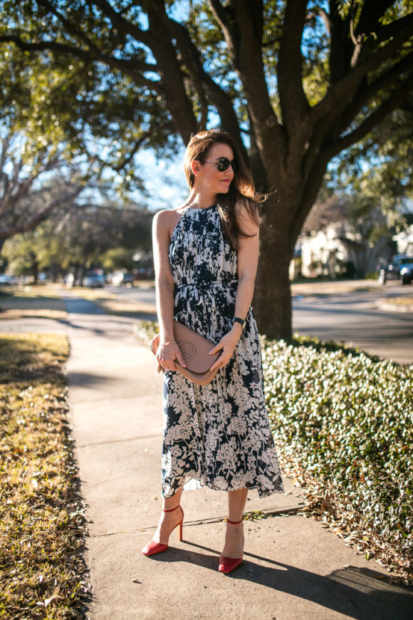 Amy Havins wears a printed midi dress and red heels. 