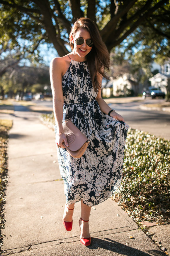 Amy Havins wears a printed midi dress and red heels. 