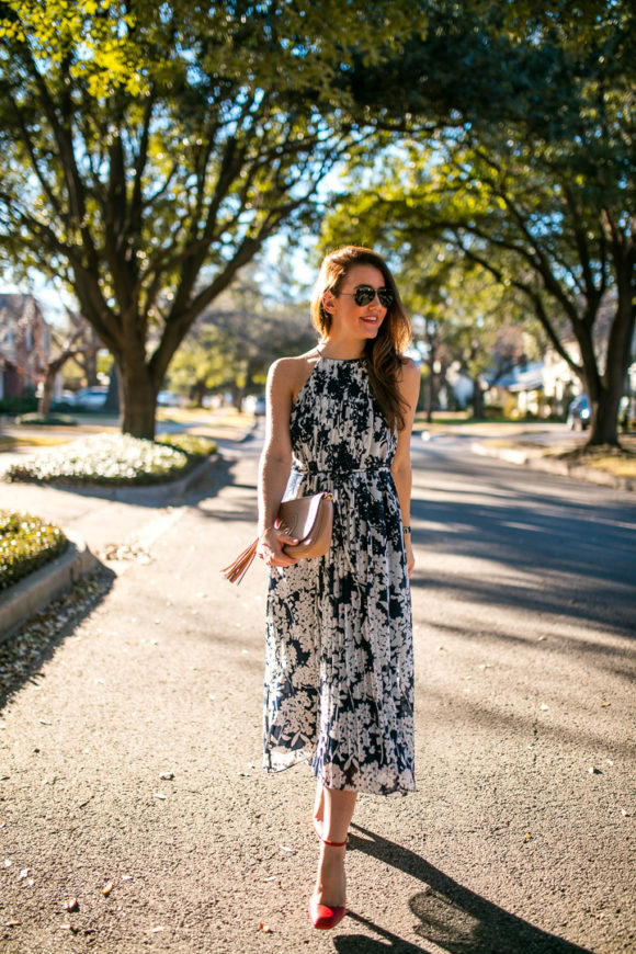 Amy Havins wears a printed midi dress and red heels. 