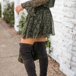 Amy Havins wears gray over the knee boots and a green dress.