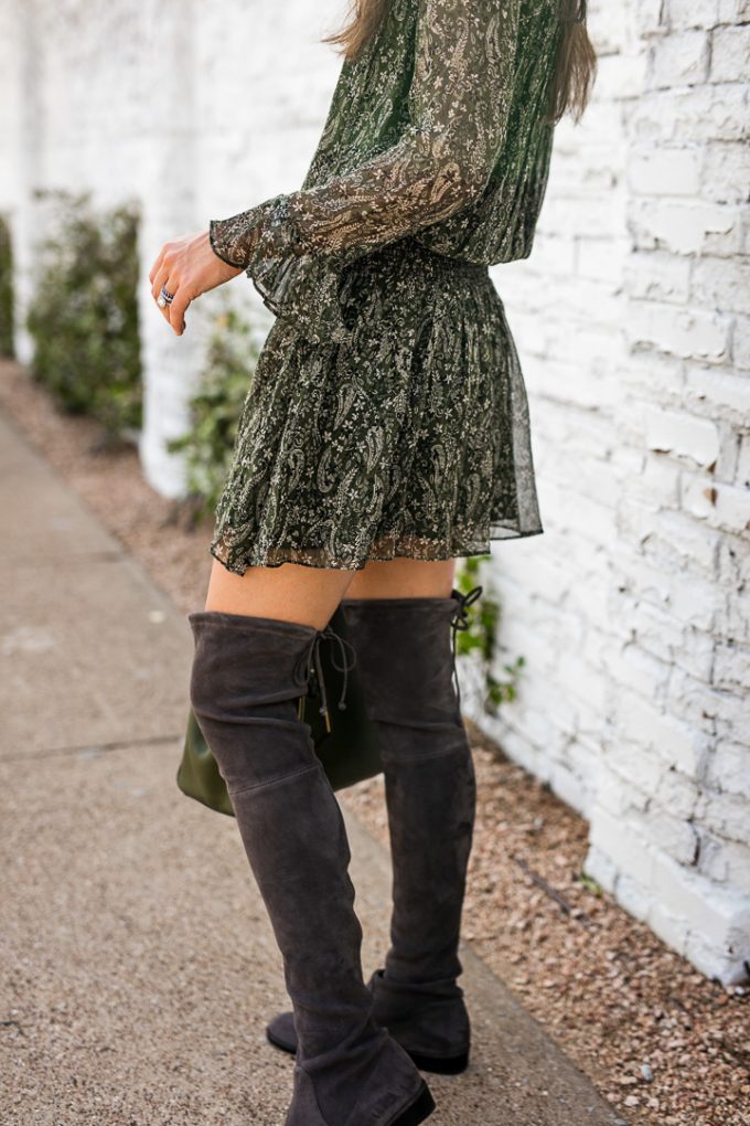 Amy Havins wears gray over the knee boots and a green dress.