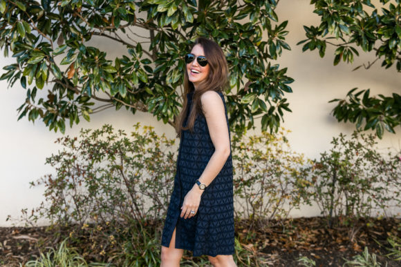 Amy havins wears a navy shift dress and spring sandals.