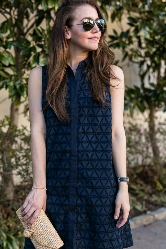 Amy havins wears a navy shift dress and spring sandals.