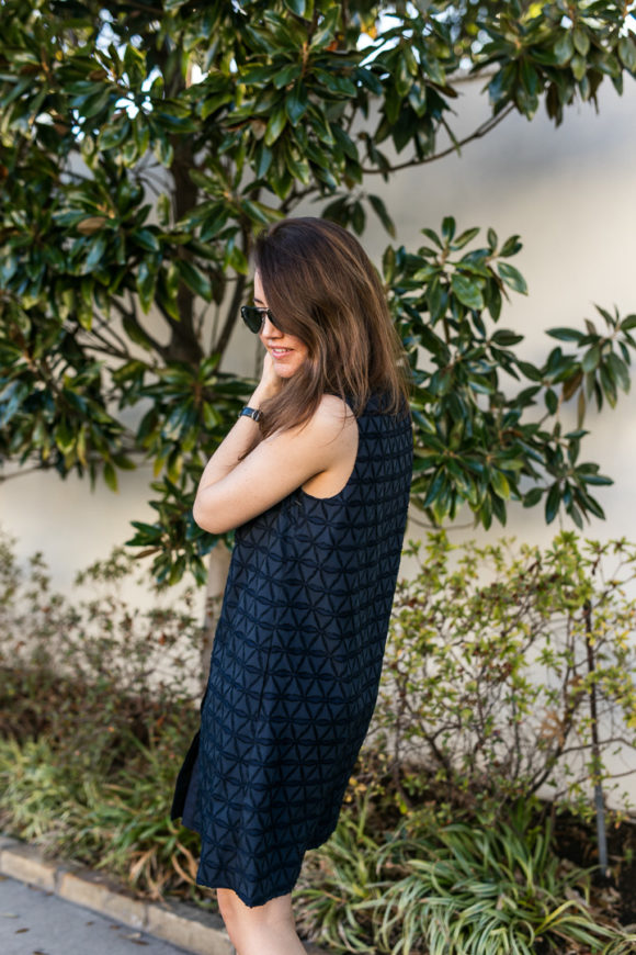 Amy havins wears a navy shift dress and spring sandals.