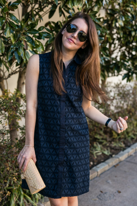 Amy havins wears a navy shift dress and spring sandals.