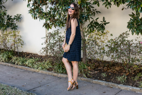 Amy havins wears a navy shift dress and spring sandals.