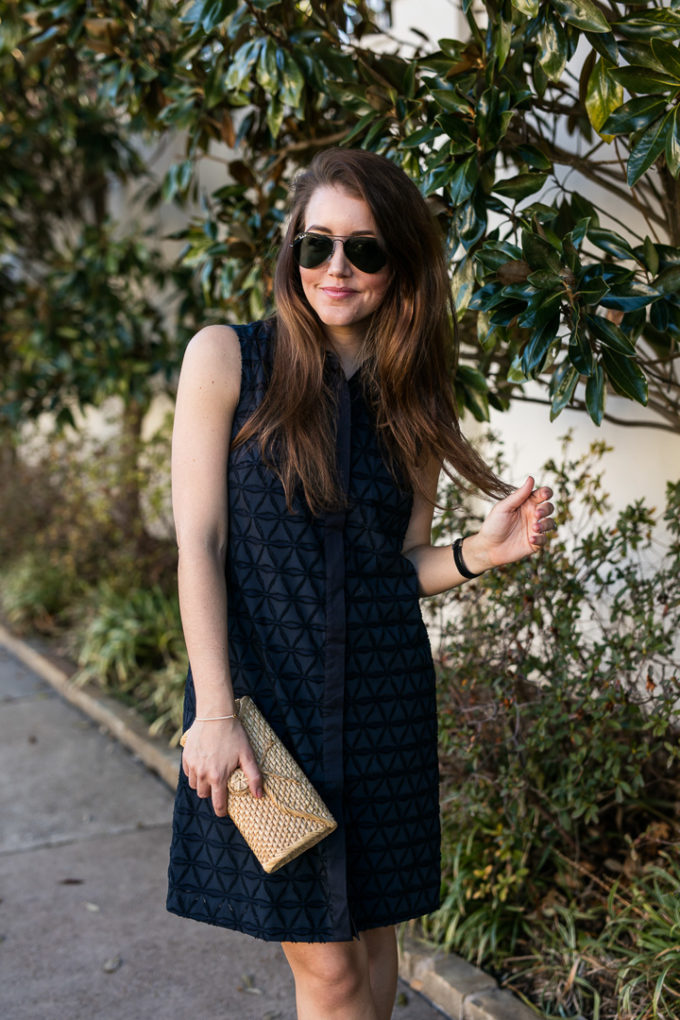 Amy havins wears a navy shift dress and spring sandals.