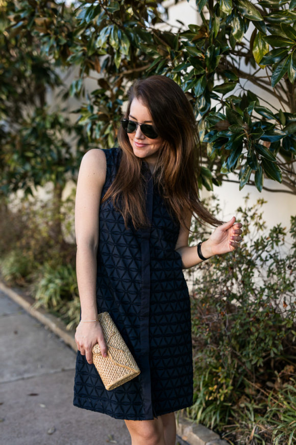 Amy havins wears a navy shift dress and spring sandals.