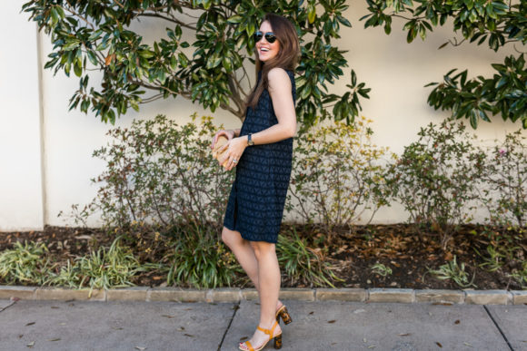 Amy havins wears a navy shift dress and spring sandals.