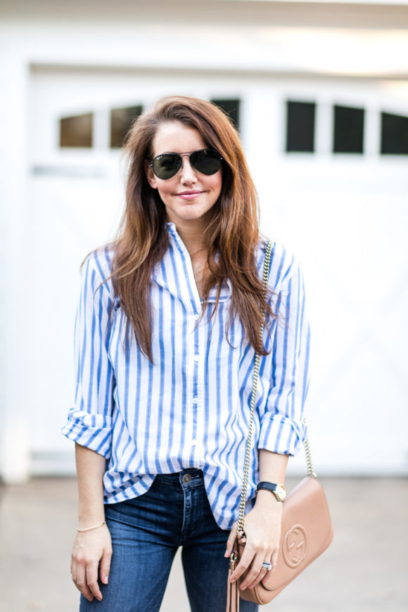 Amy Havins wears ripped jeans and a blue and white button down.