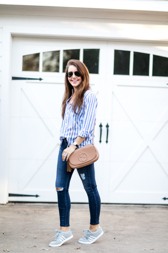 Amy Havins wears ripped jeans and a blue and white button down.