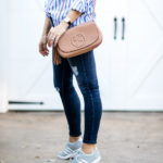 Amy Havins wears ripped jeans and a blue and white button down.