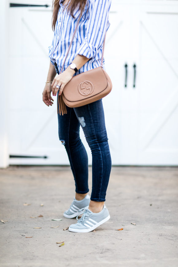 Amy Havins wears ripped jeans and a blue and white button down.