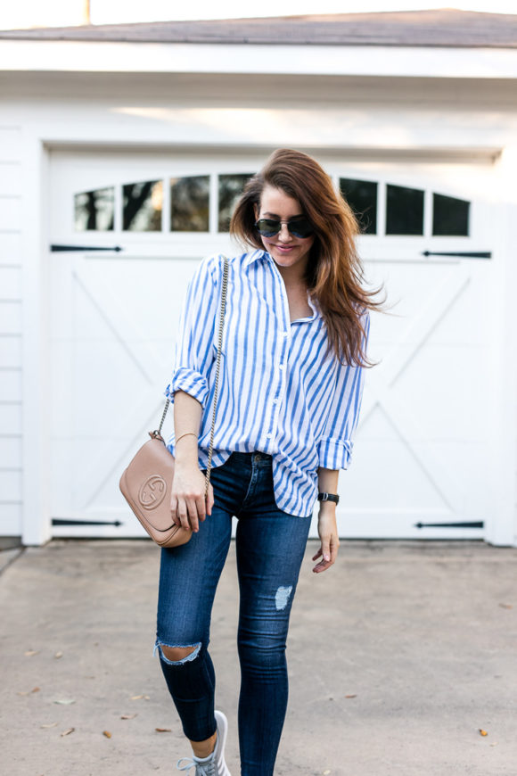 Amy Havins wears ripped jeans and a blue and white button down.