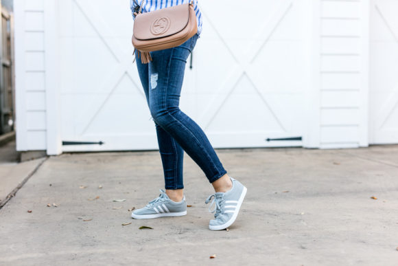 Amy Havins wears ripped jeans and a blue and white button down.