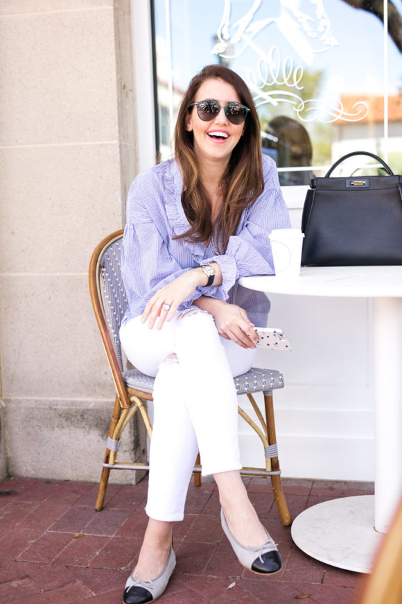 Amy havins wear a blue and white blouse with white jeans.