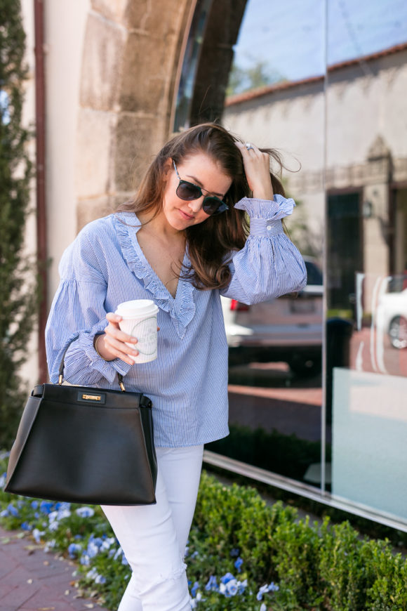 Amy havins wear a blue and white blouse with white jeans.