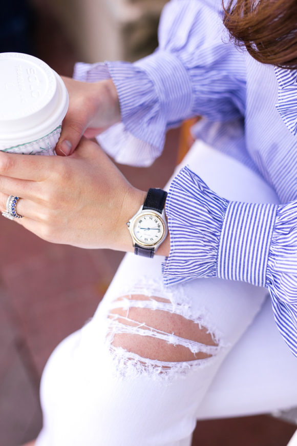 Amy havins wear a blue and white blouse with white jeans.