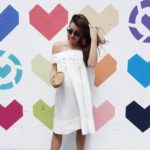 Amy Havins wears a white off the shoulder maternity dress.