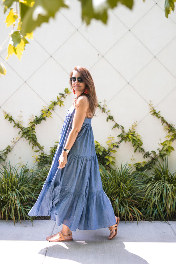 Amy Havins wears a denim tiered maxi dress with flats.