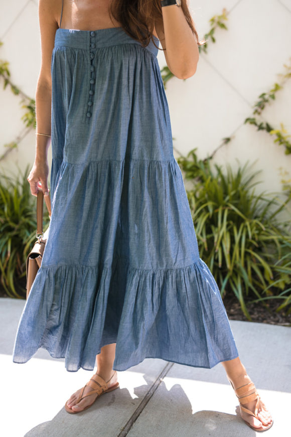 Amy Havins wears a denim tiered maxi dress with flats.