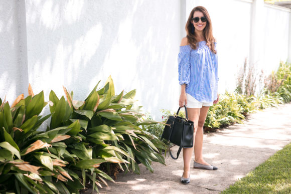 Amy Havins wears a blue and white off the shoulder blouse and white shorts.