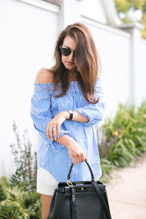 Amy Havins wears a blue and white off the shoulder blouse and white shorts.