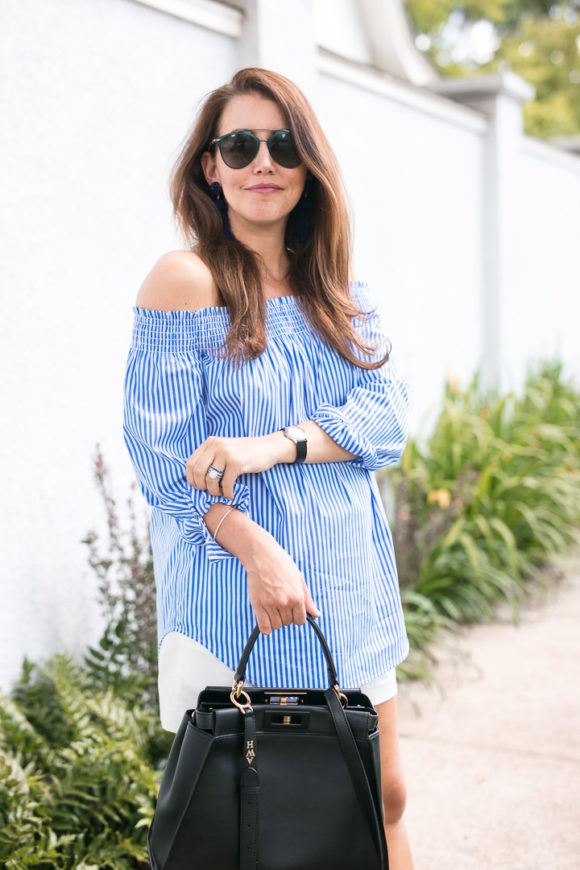 Amy Havins wears a blue and white off the shoulder blouse and white shorts.