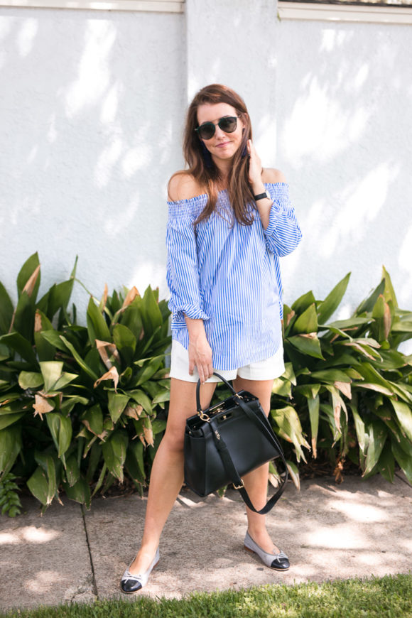 Amy Havins wears a blue and white off the shoulder blouse and white shorts.