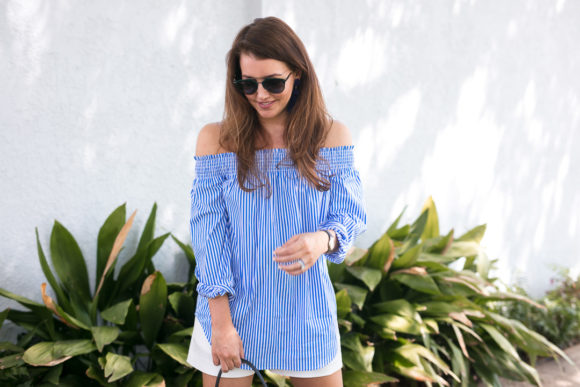 Amy Havins wears a blue and white off the shoulder blouse and white shorts.