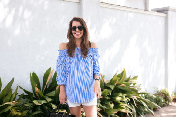 Amy Havins wears a blue and white off the shoulder blouse and white shorts.