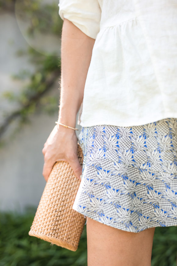 Amy Havins wears ruffle shorts and a white linen blouse.