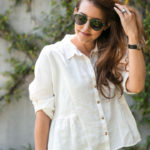 Amy Havins wears ruffle shorts and a white linen blouse.