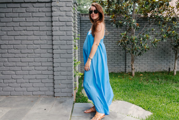 Amy Havins wears a blue maxi dress and neutral flats.