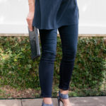 Amy havins wears a navy tunic, jeans and jimmy choo sandals.