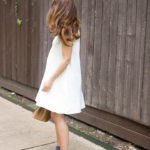 Amy Havins wears a white summer dress with blue jimmy choo heels.