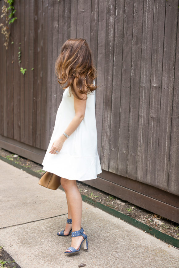 Amy Havins wears a white summer dress with blue jimmy choo heels.