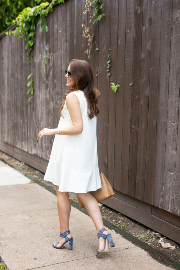 Amy Havins wears a white summer dress with blue jimmy choo heels.