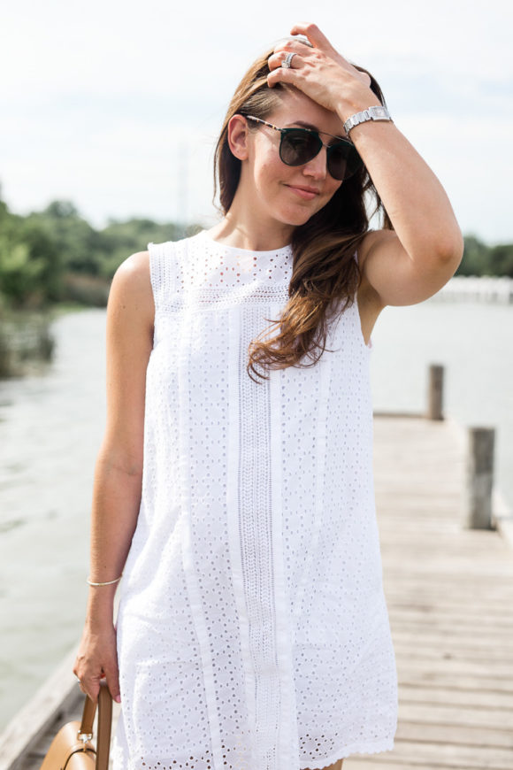 Amy Havins wears a white eyelet shift dress.