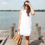 Amy Havins wears a white eyelet shift dress.