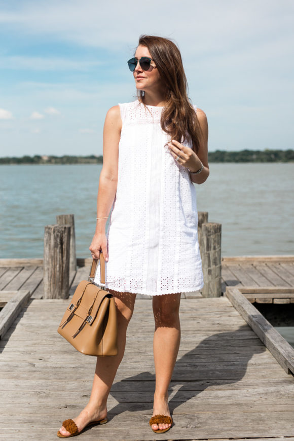 Amy Havins wears a white eyelet shift dress.