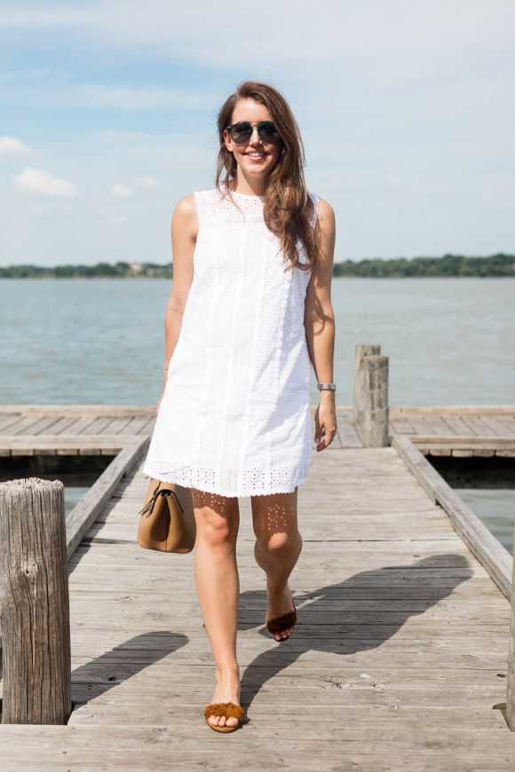 Amy Havins wears a white eyelet shift dress.